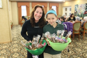 KSDS Director of Community Outreach & Engagement, Liz Minkin Friedman and Grade 5 student, Ahuva, deliver treats to Weinberg residents.