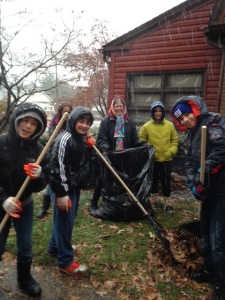 Grade 6 students and parents help clean up around the CHAI Housing. 